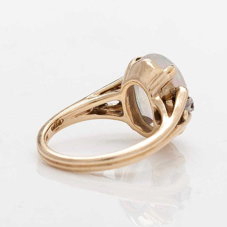 Ring in 14K gold with an oval opal and diamonds.