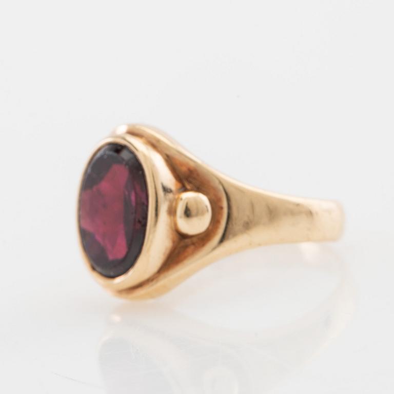 Ring 18K guld med en ovalt slipad granat.