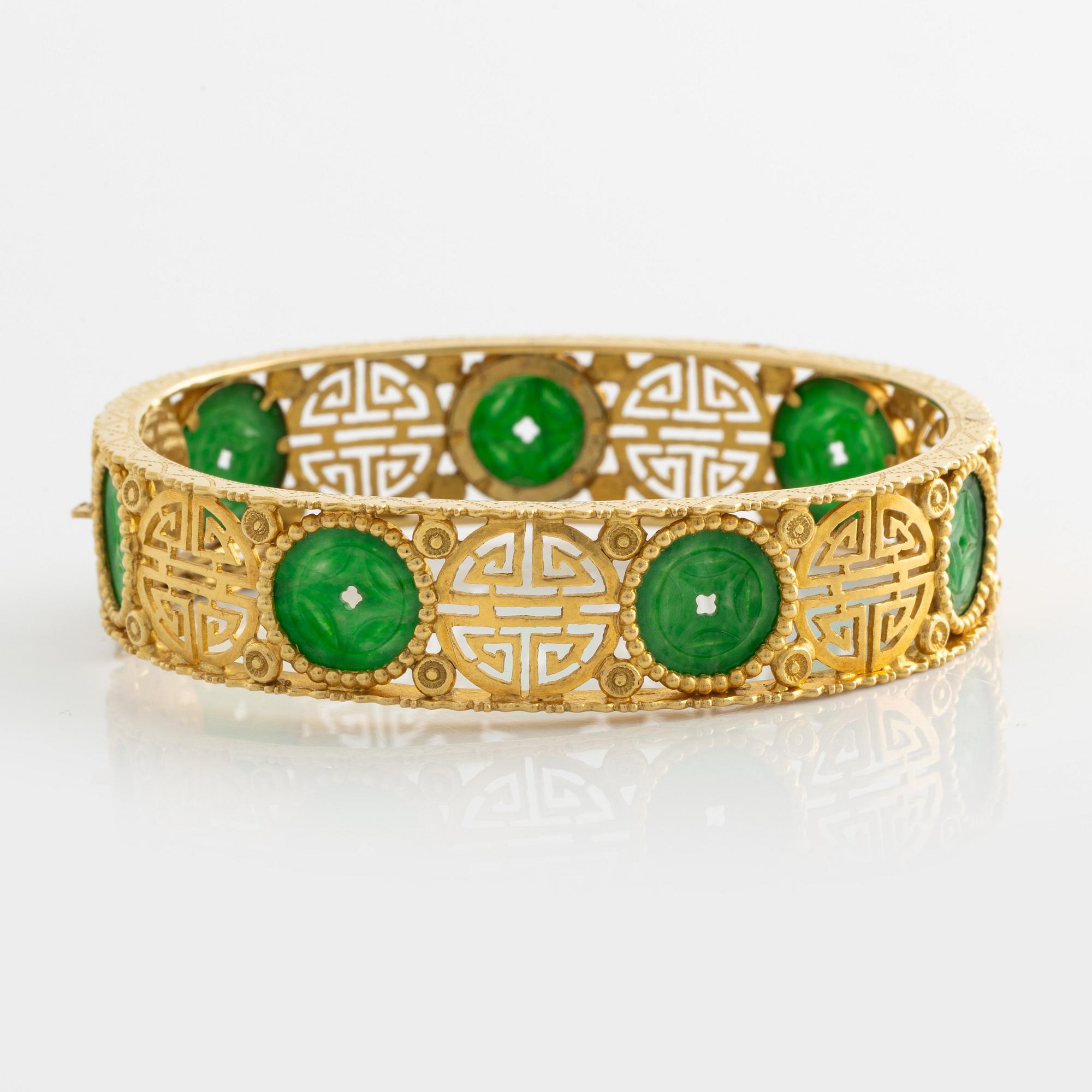 Armring guld med grön sten, troligen jadeit.
