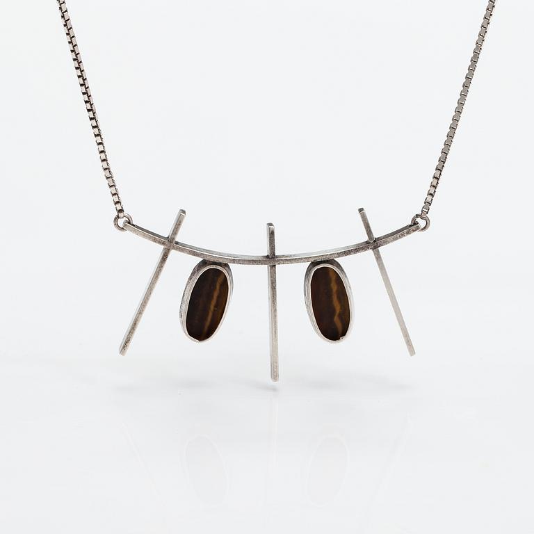 Kaulakoru, hopeaa ja tiikerinsilmää. Eero Eskelinen, Helsinki 1959.