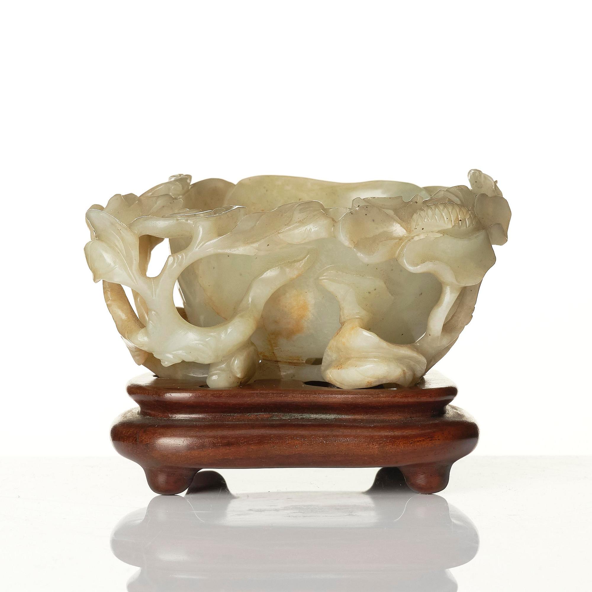 A carved Chinese nephrite cup in the shape of a lotus leaf, late Ming dynasty.