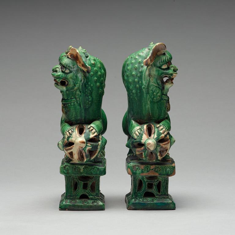 A pair of green glazed buddhist lions, Ming dynasty (1368-1644).