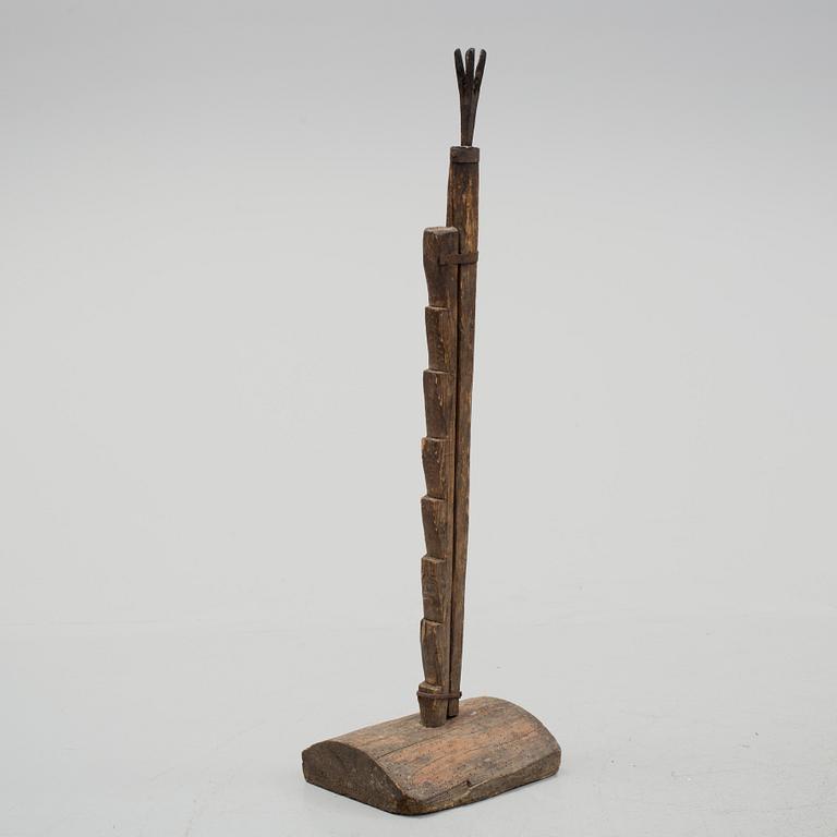 A 18th century wooden floor candle holder.