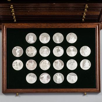 100 sterling silver coins in a wooden cabinet by Franklin Mint.