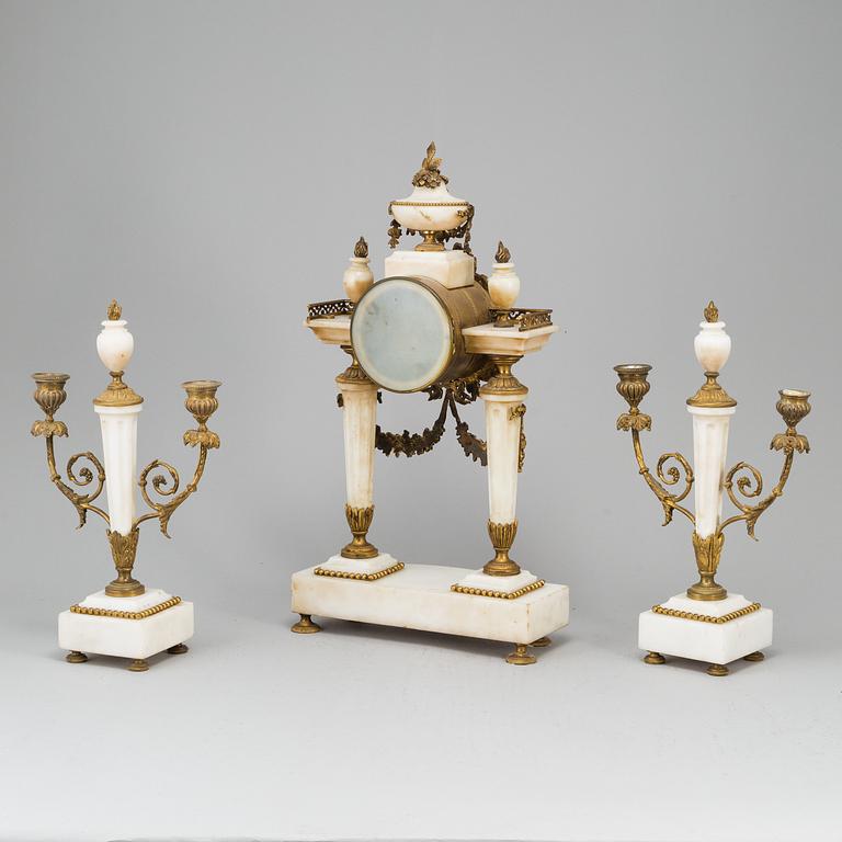 A Louis XVI-style mantle clock and a pair of candelabras. Early 20th century.
