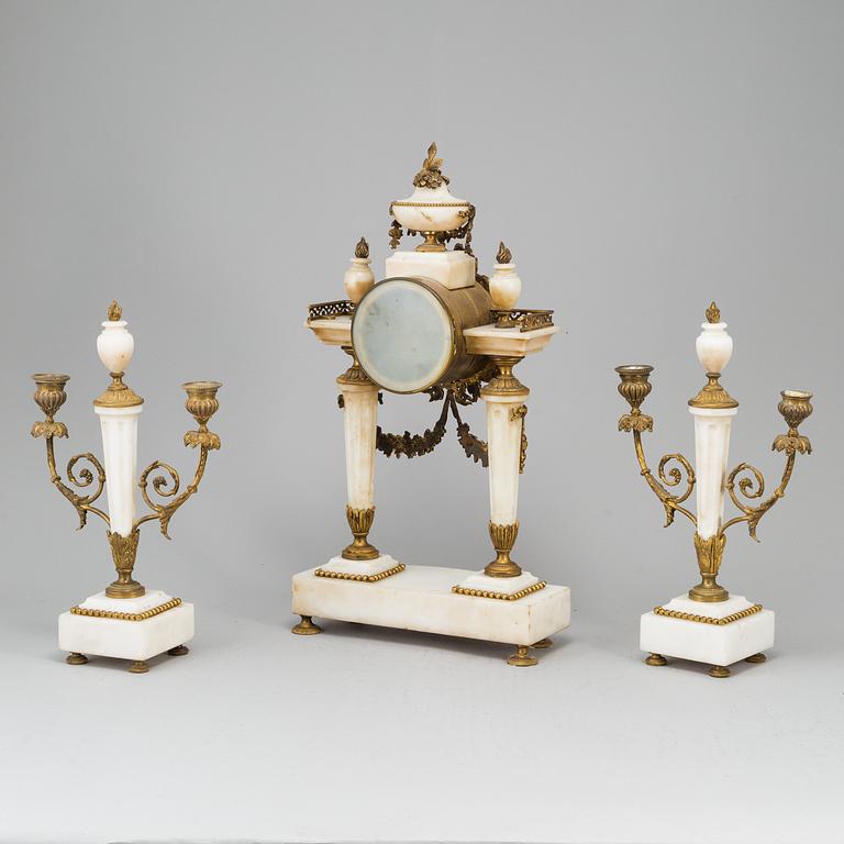 A Louis XVI-style mantle clock and a pair of candelabras. Early 20th century.