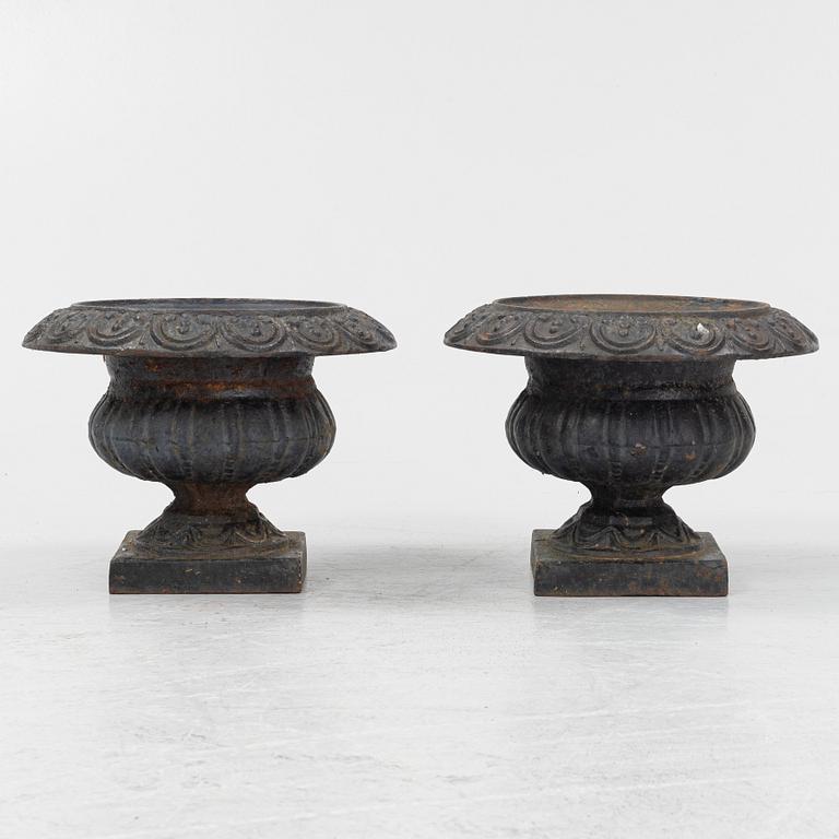 A pair of cast iron garden urns, 20th century.