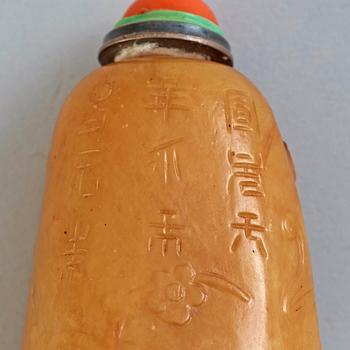 A soapstone snuff bottle with a carved landscape and a nine-character inscription, late Qing dynasty (1644-1912).