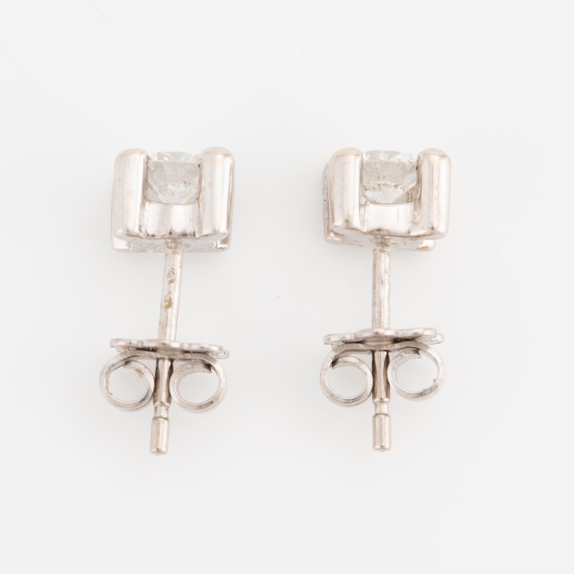 A pair of earrings in 18K white gold set with two round brilliant-cut diamonds.