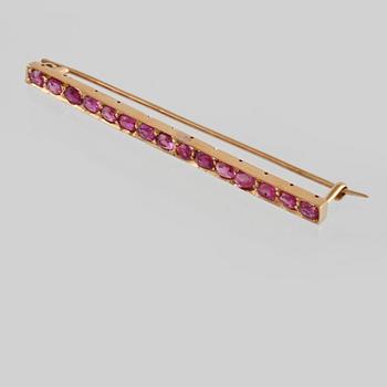 BROSCH, 18K guld med 15 fasettslipade rubiner. Vikt 4,8 gram.