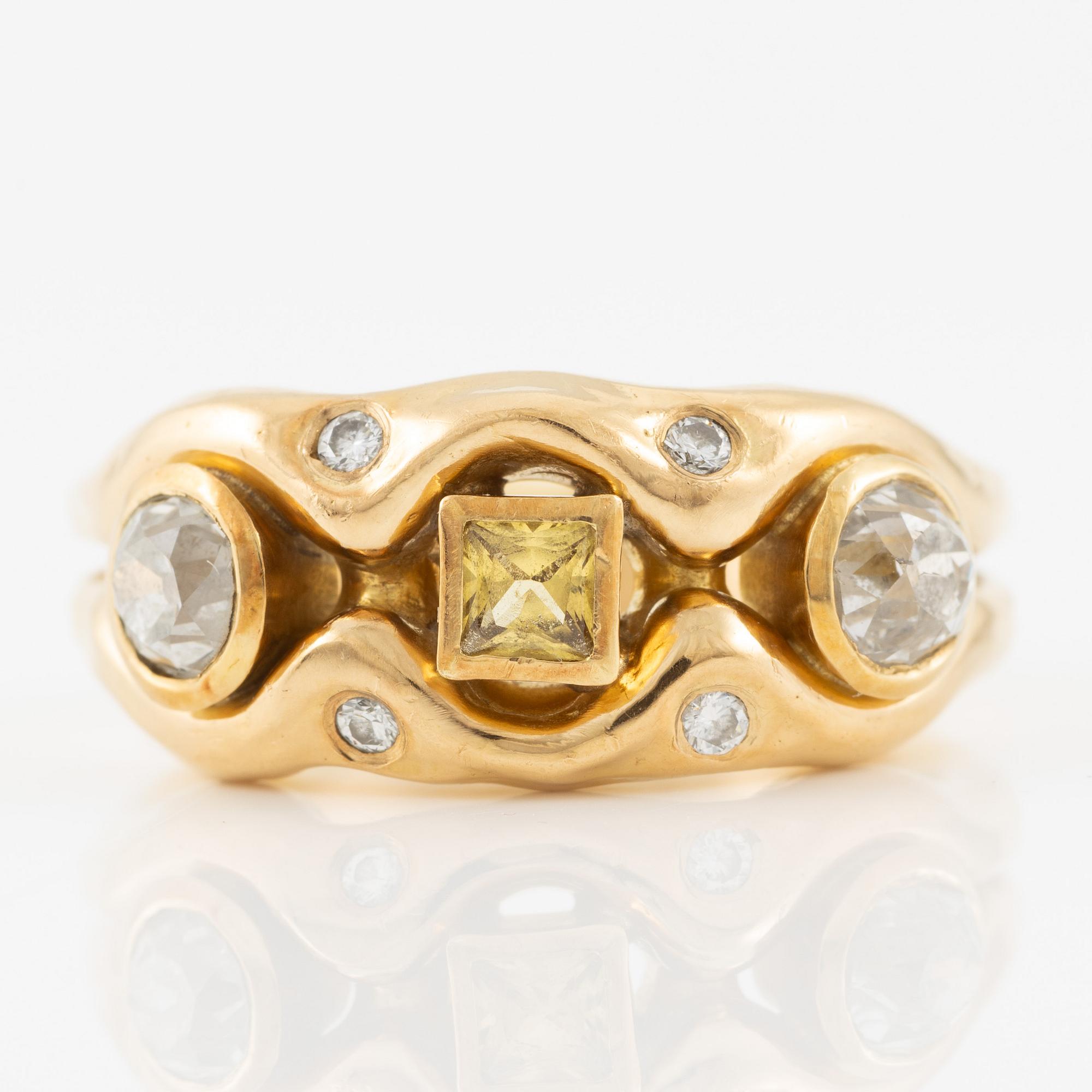 Ring in 18K gold set with old-cut diamonds and a faceted yellow sapphire.