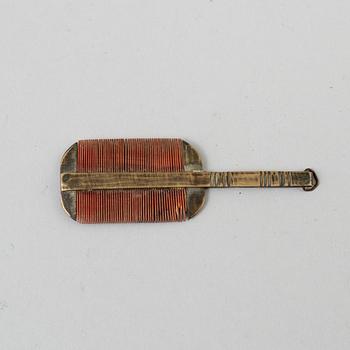 A 18th century brass comb.