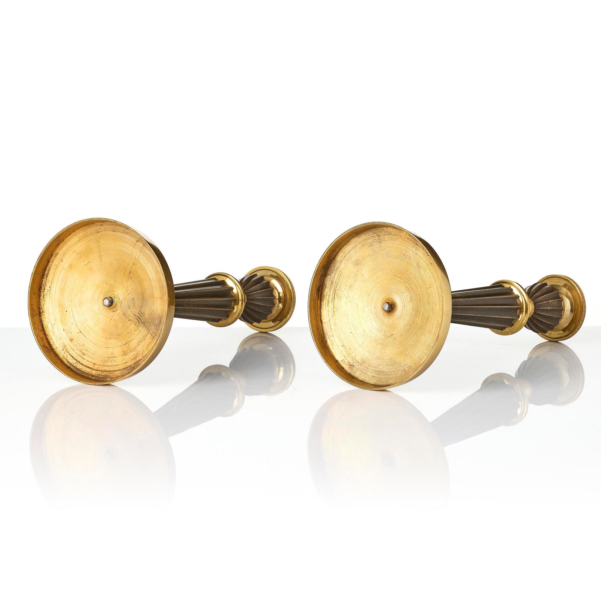 A pair of French Empire patinated and ormolu candlesticks, early 19th century.
