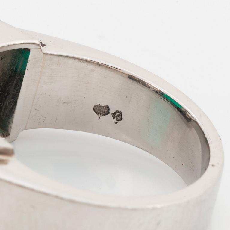 Ring platina med en trappslipad smaragd och runda briljant- och fasettslipade diamanter.