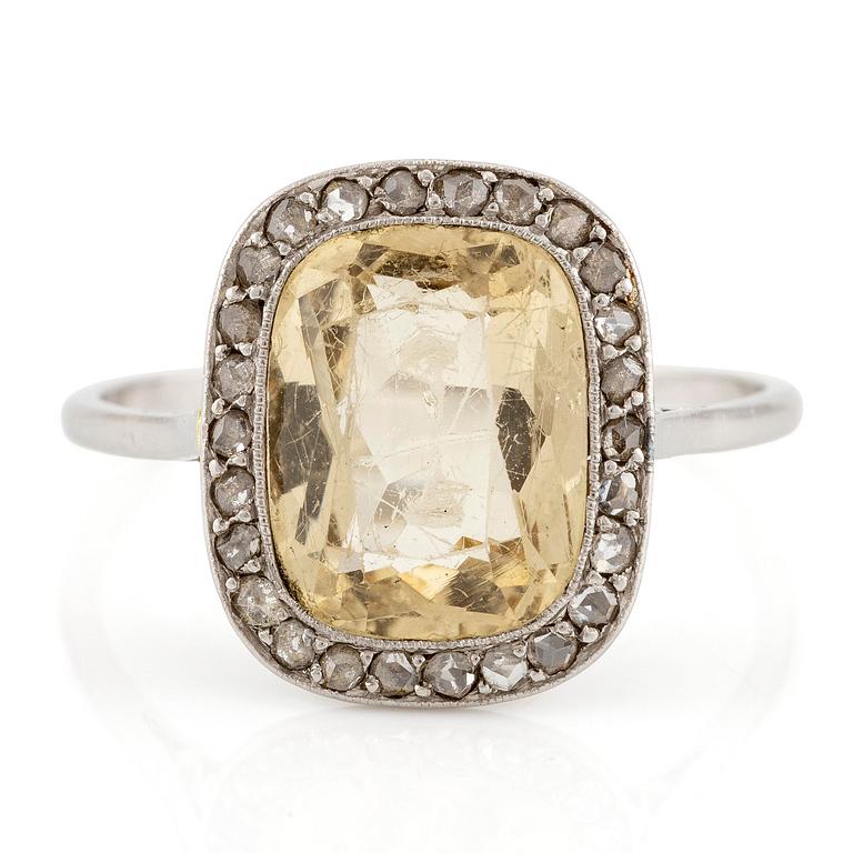 A ring in 18K white gold set with a yellow faceted tourmaline and rose-cut diamonds.