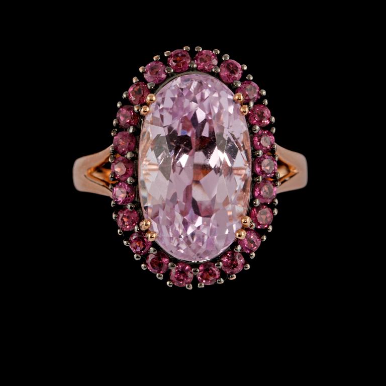 RING, 18K guld med ovalslipad rosa kunzit 9.41 ct samt fasettslipade granater 1.15 ct. Vikt 6,9 gram.