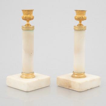 A pair of marble and gilt-bronze Louis XVI-style candelsticks, circa 1900.