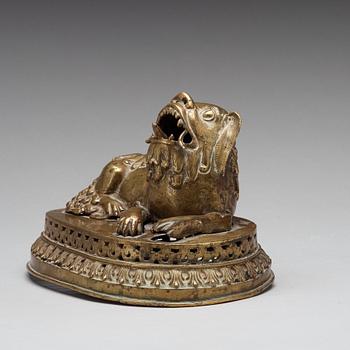 A copper alloy figure of a reclining buddhist lion, presumably 18th Century.