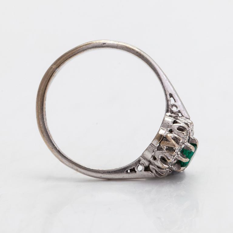 An 18K gold ring with an emerald and diamonds totalling approx. 0.04 ct.