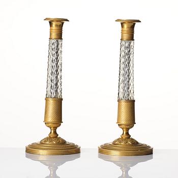 A pair of French gilt bronze and cut-glass Empire-style candlesticks, later part of the 19th century.