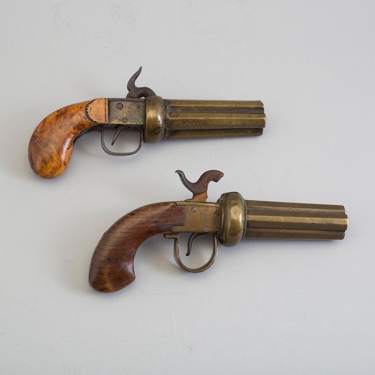 SLAGLÅSREVOLVRAR, 2 st, svenska, i mässing, fyrpipiga, varav 1 signerad.