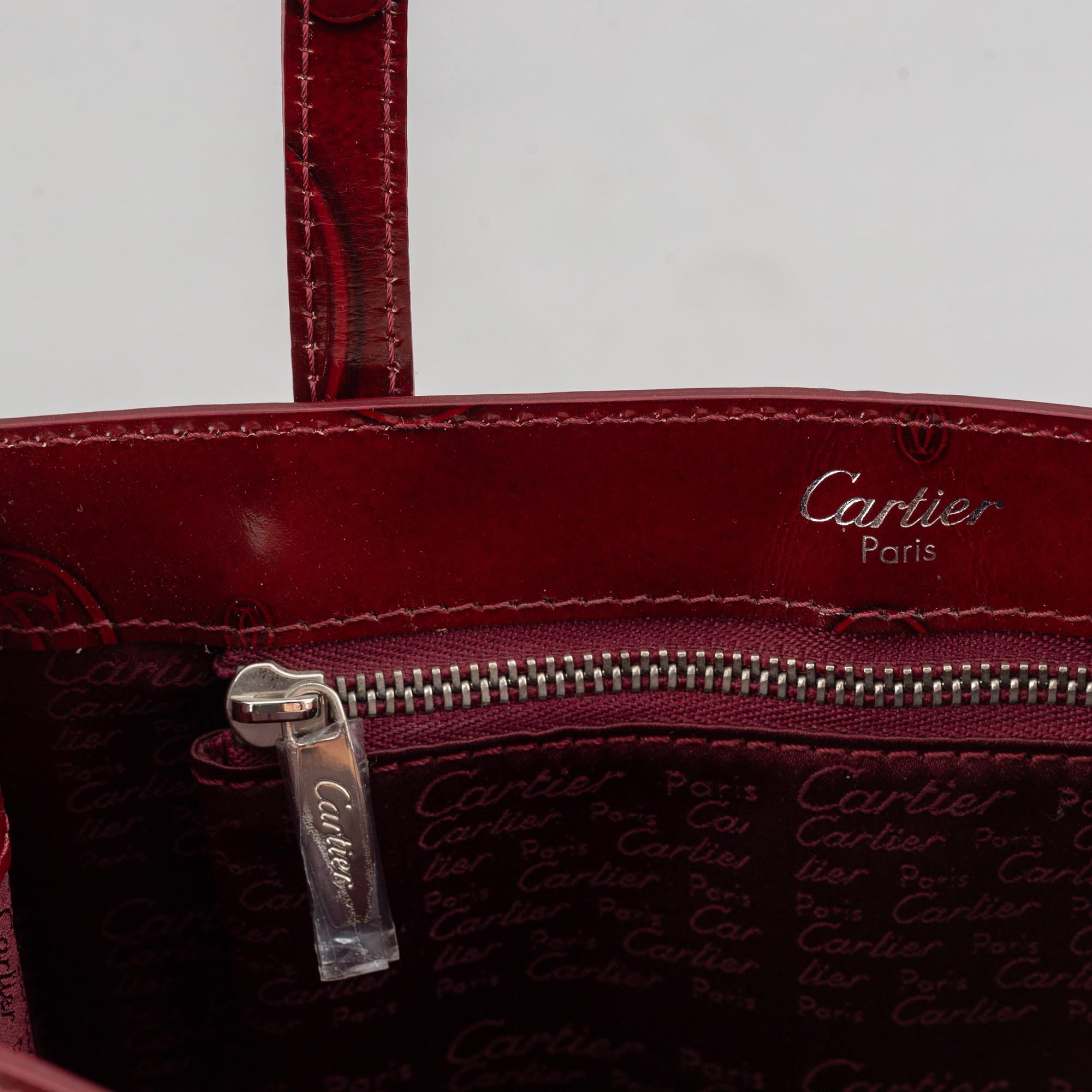 Cartier, a burgundy patent leather handbag and wallet.