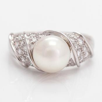 An 18K white gold ring, with a cultured pearl and diamonds totalling approximately 0.70 ct.