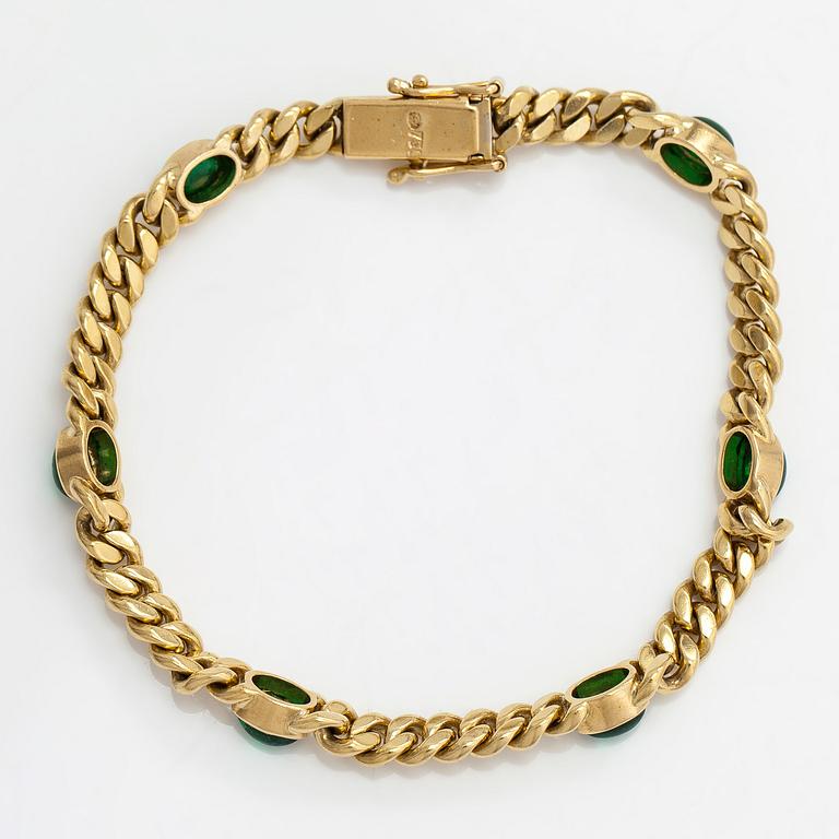 An 18K gold curb link bracelet with cabochon-cut green garnets.