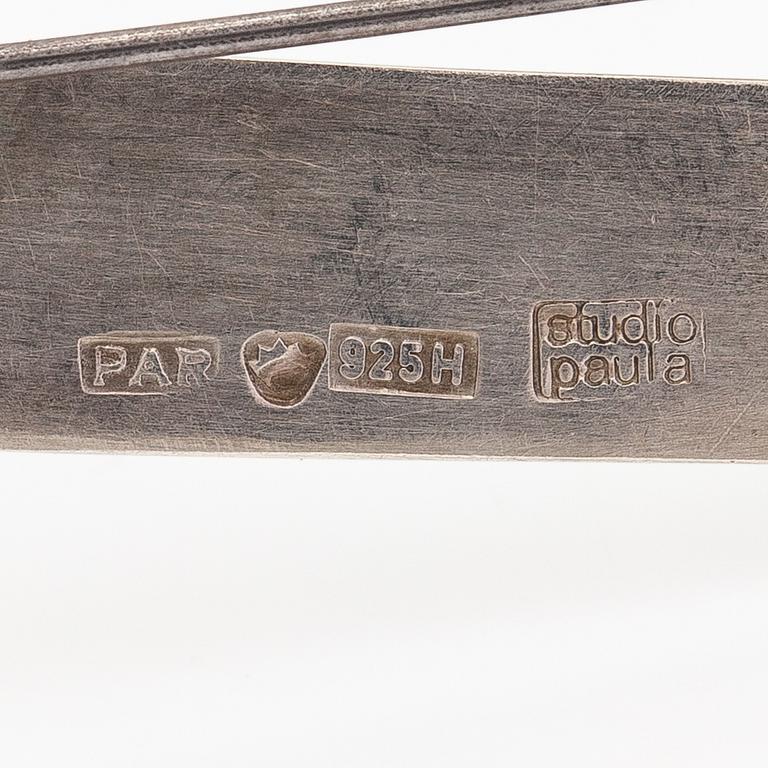 Paula Häiväoja, Rintaneula "Jostakin Alkaen", sterlinghopeaa ja kultaa. Pentti Roos/Studio Paula, Helsinki.