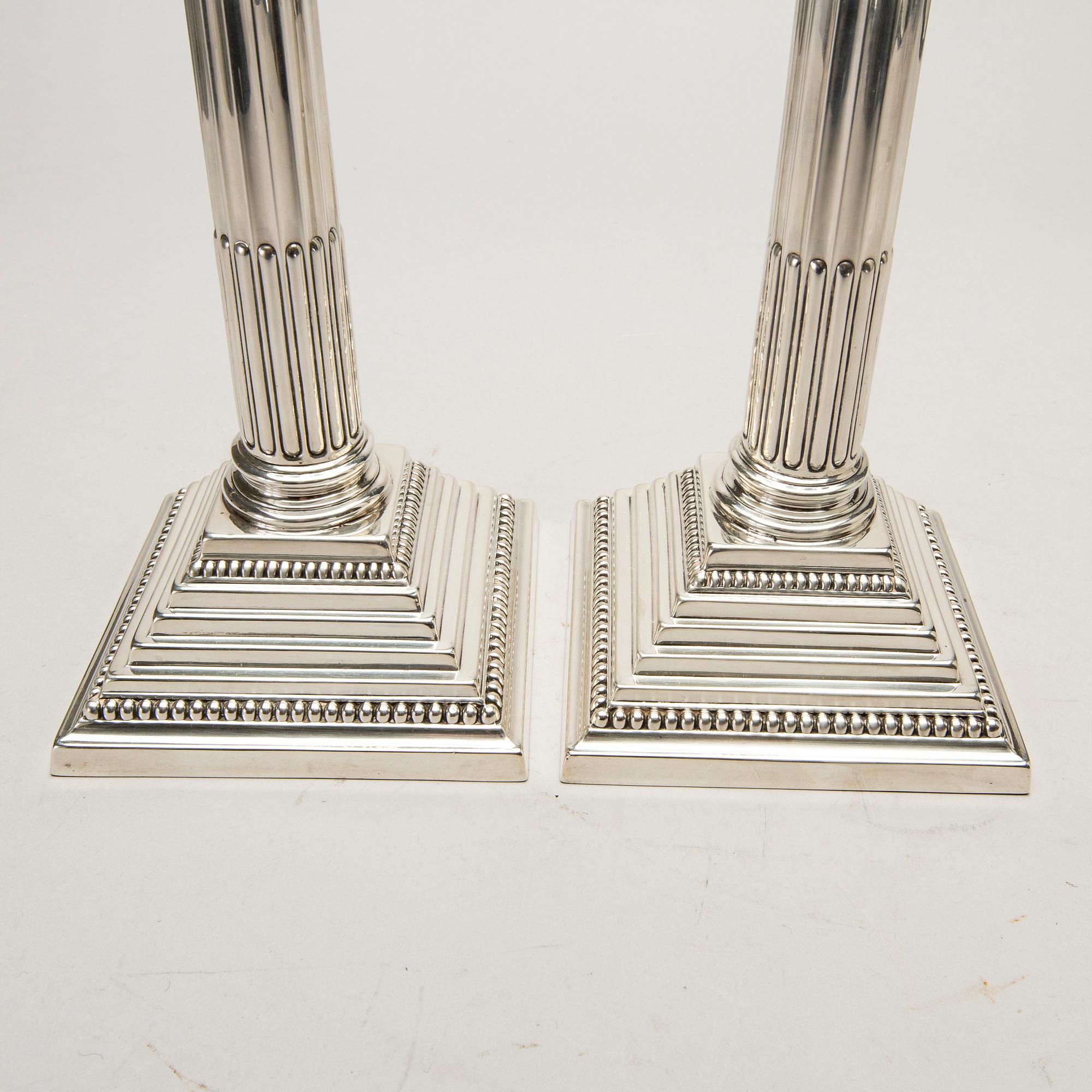 A pair of classical column sterling silver candlesticks Birmingham, 1934, by 'B.G. & Co'.