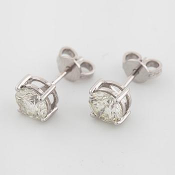 A pair of brilliant cut diamond earrings.