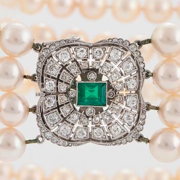 A four strand cultured pearl necklace with an 18K white gold clasp set with a faceted emerald.