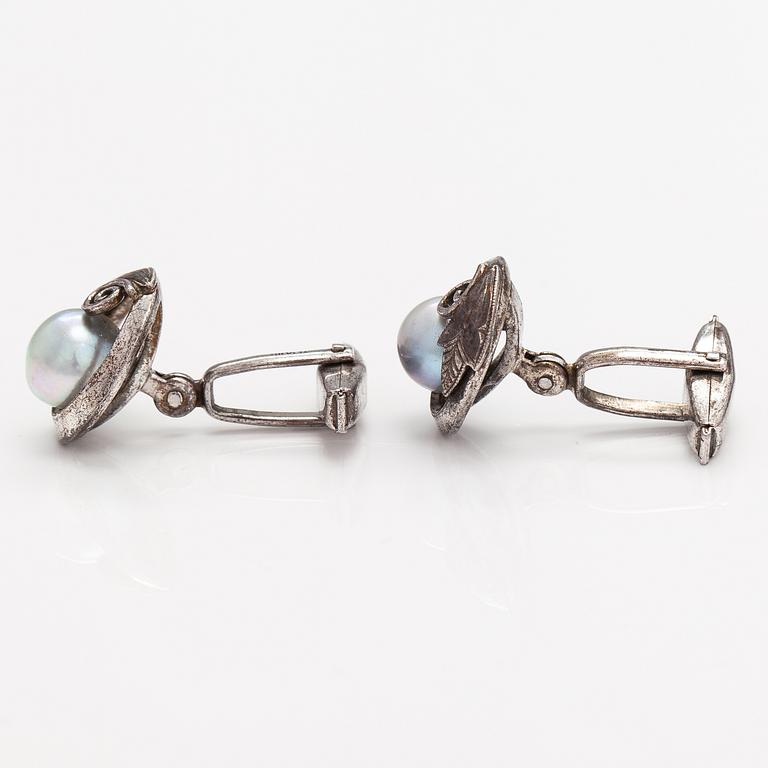 A pair of silver cufflinks with cultured baroque/Akoya pearls.