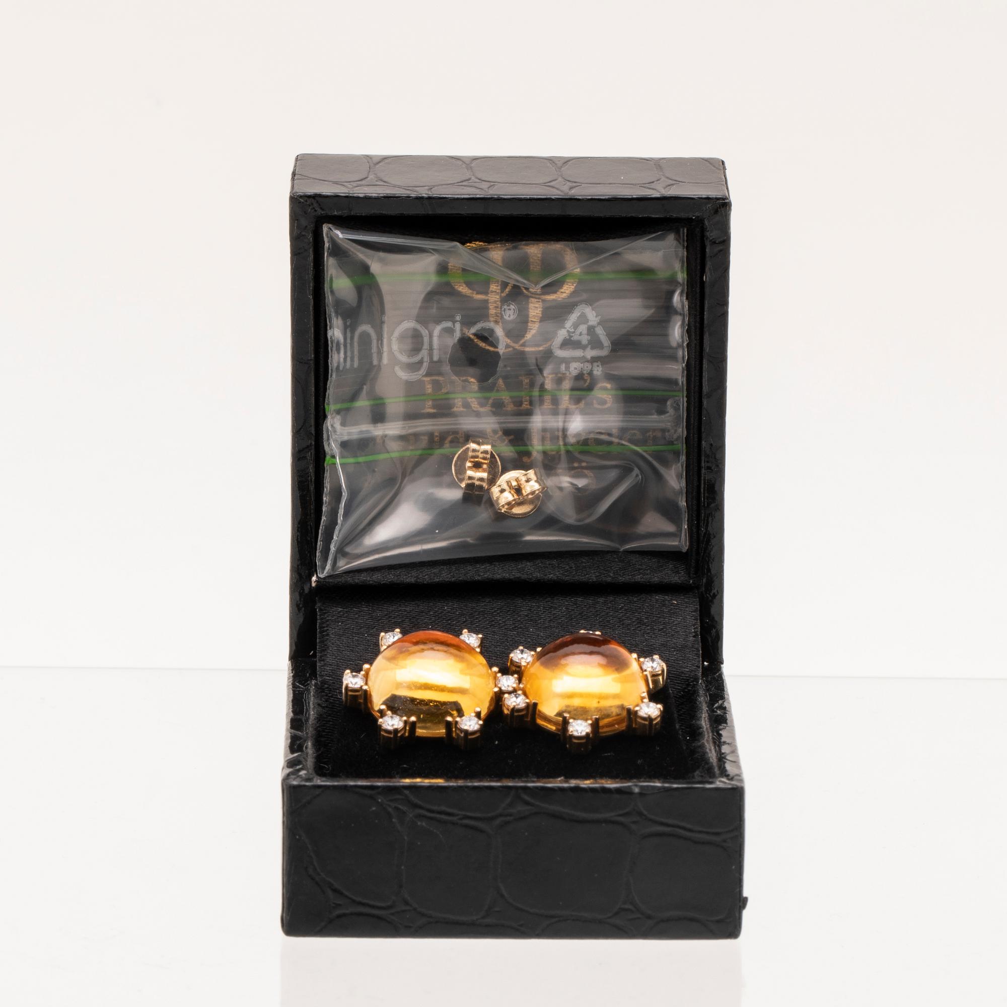A pair of 18K gold earrings set with cabochon cut citrines and round brilliant cut diamonds.
