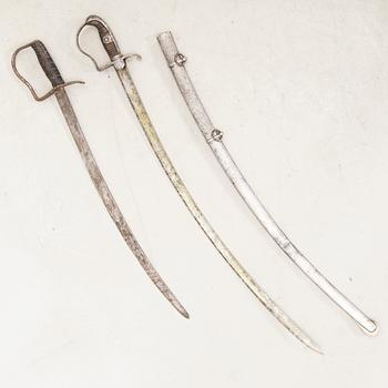 A German sabre with scabbard and a cutlass.