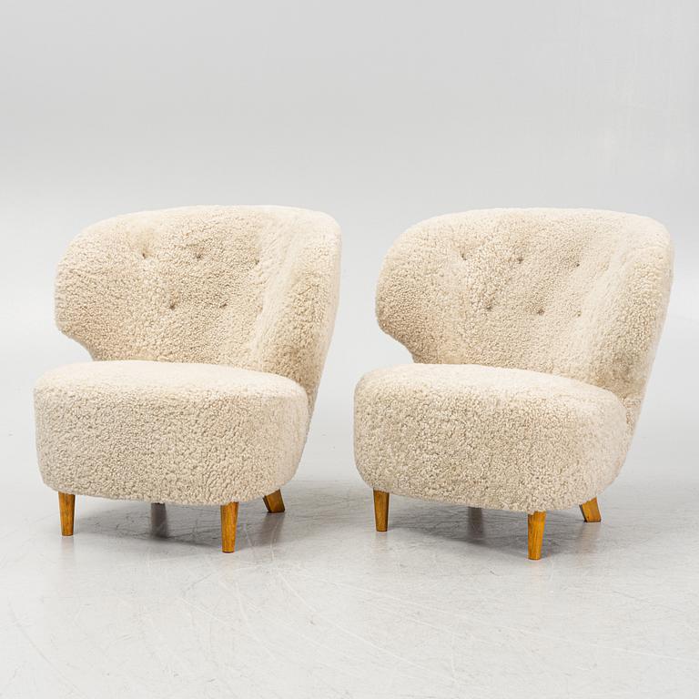A pair of Scandinavian Modern 1940s cheepskin armchairs.