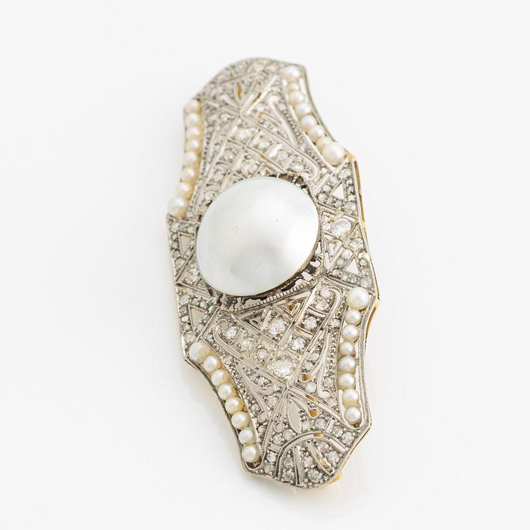 Brooch in 18K gold and platinum with a cultured half-pearl, pearls, diamonds in various cuts, and white stones.