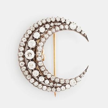 369. A crescent moon brooch in silver and gold set with old- and rose-cut diamonds.