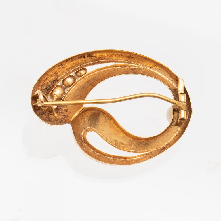 An 18K gold brooch with cultured pearls.