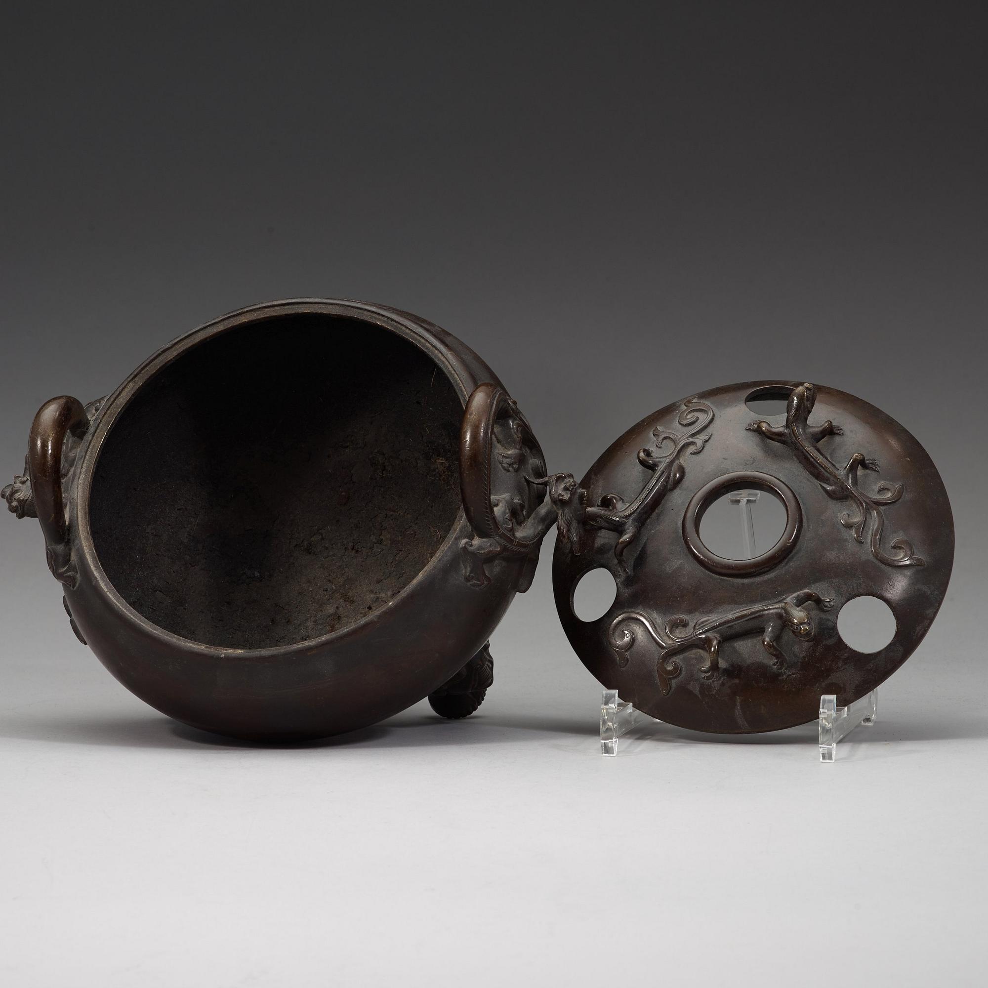 A bronze tripod censer with cover and stand, Qing dynasty, 17/18th Century.