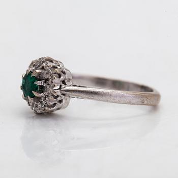 An 18K gold ring with an emerald and diamonds totalling approx. 0.04 ct.