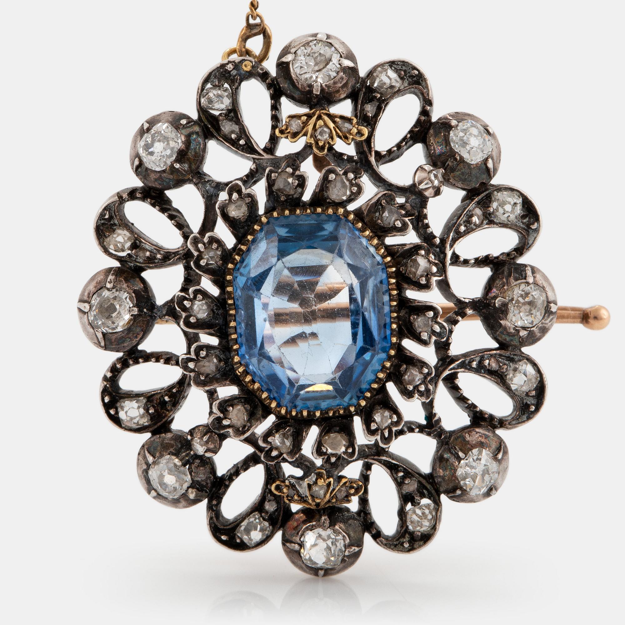 Brosch silver och 14K guld med en synetisk safir samt gammal- och rosenslipade diamanter.
