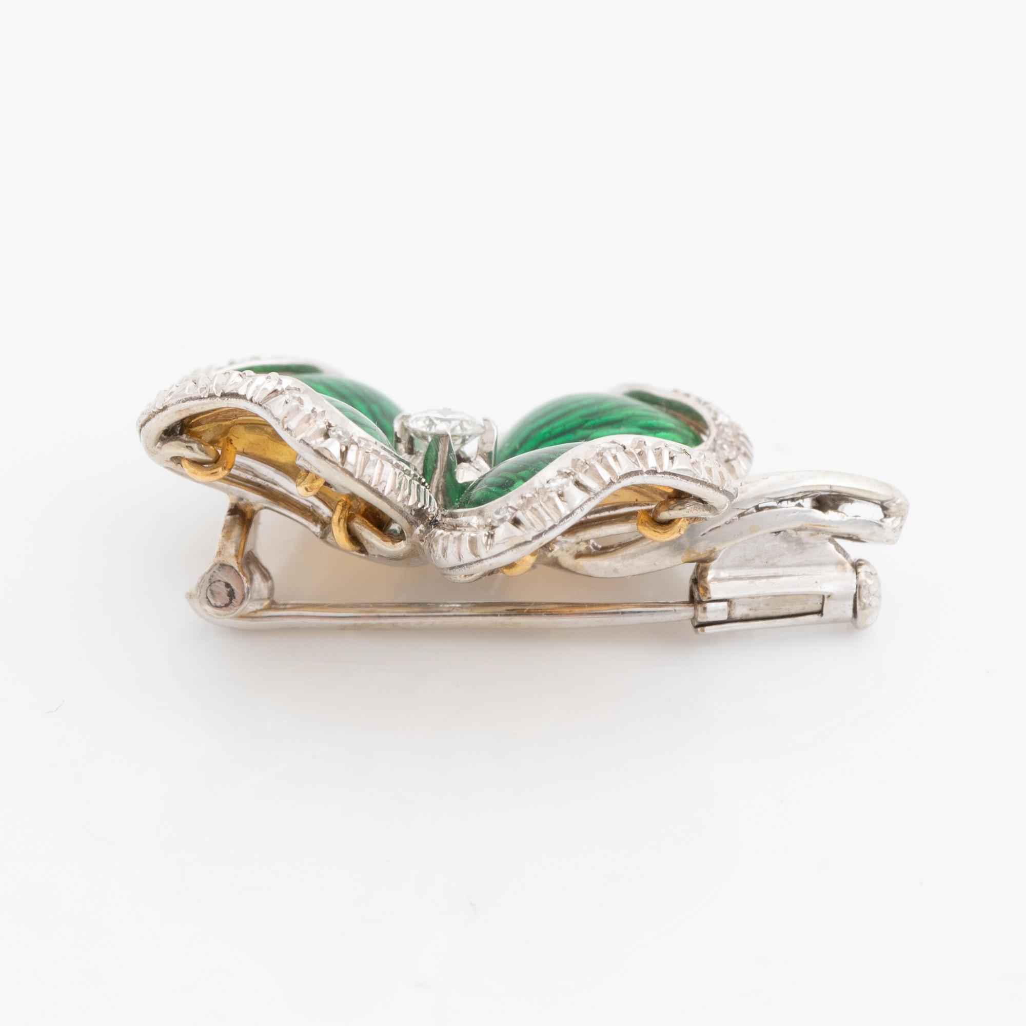 An 18K gold and enamel brooch set with round brilliant-cut diamonds.