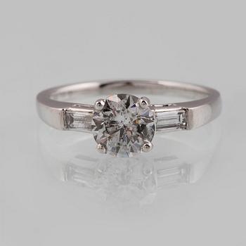 RING, 18K vitguld med briljantslipad diamant ca 1.05 ct samt 2 baguettslipade diamanter ca 0.17 ct. Vikt 3,2 gram.