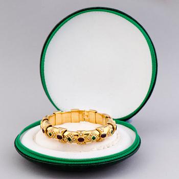 RANNEKORU, viistehiotut smaragdit ja rubiinit, briljanttihiotut timantit, 18K kultaa.