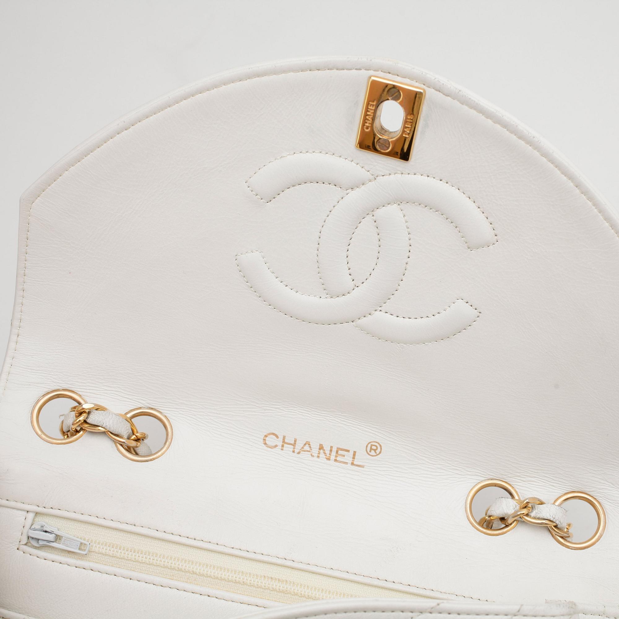 CHANEL, a white leather shoulder bag.