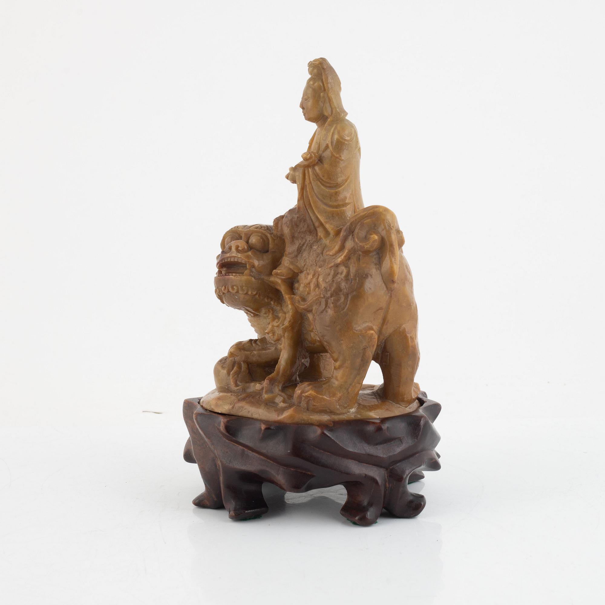 A soapstone guanyin with wooden stand, China, late Qing dynasty/early 20th century.