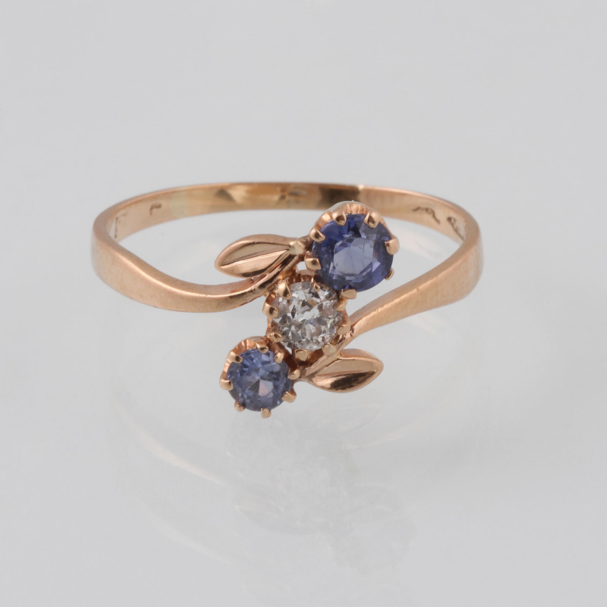 RING, 18K guld med äldre briljantslipad diamant samt 2 fasettslipade blå safirer.