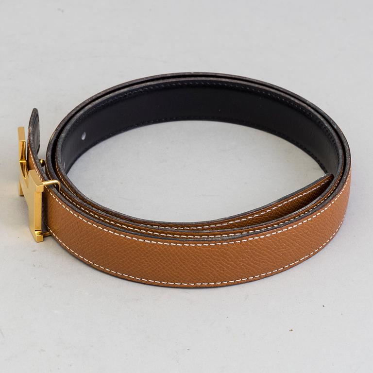 A Hermès "H" belt buckle with reversible leather strap noir/gold.