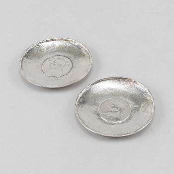 A pair of Chinese silver dishes, with coins, 20th Century.